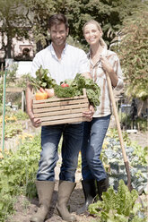 Porträt eines reifen Paares im Garten, das eine Kiste mit frischem Gemüse hält - ISF08932