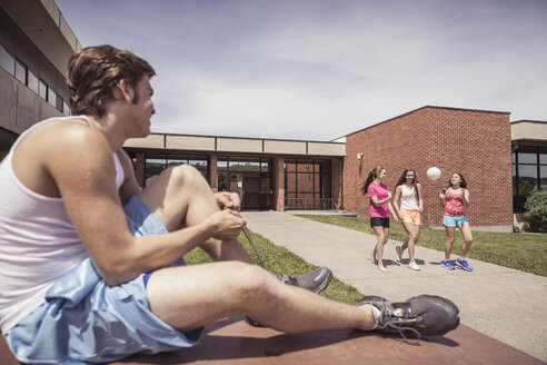 Teenager in der High School bindet die Schnürsenkel für den Volleyball außerhalb der Schule - ISF08973