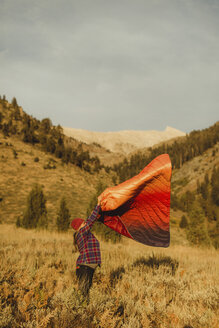 Schwangere Frau steht im Feld und schüttelt ihren Schlafsack aus, Mineral King, Sequoia National Park, Kalifornien, USA - ISF08994