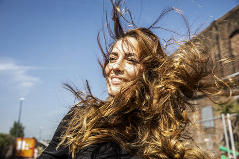 Portrait of smiling woman with blowing hair - FMKF05090