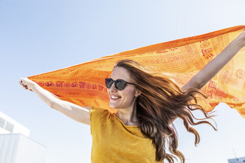 Porträt einer lächelnden Frau mit Sonnenbrille und Tuch, lizenzfreies Stockfoto