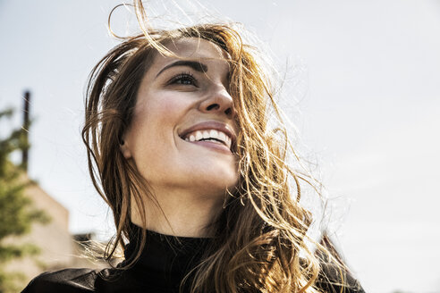 Portrait of happy woman with blowing hair - FMKF05129