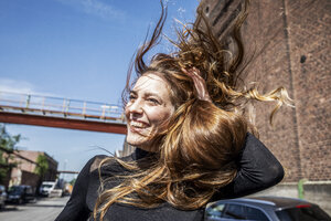 Portrait of laughing woman with blowing hair - FMKF05130