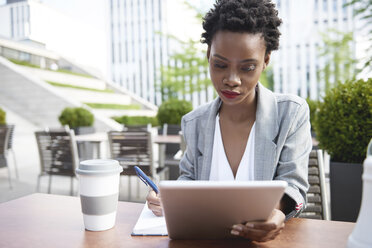 Porträt einer Geschäftsfrau, die in einem Straßencafé ein digitales Tablet benutzt - ABIF00535