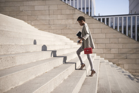 Geschäftsfrau geht die Treppe hinauf, lizenzfreies Stockfoto