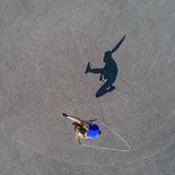 Aerial view of young woman skipping rope, shadow - STSF01596