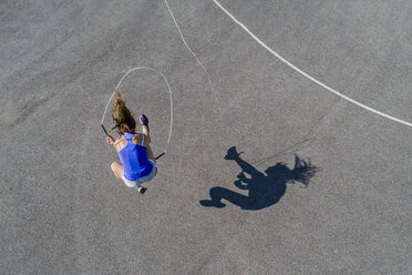 Luftaufnahme einer jungen Frau, die Seil springt, Schatten - STSF01598