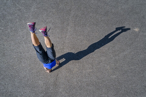 Luftaufnahme einer sportlichen jungen Frau beim Handstandtraining, lizenzfreies Stockfoto