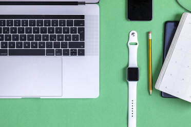 Business desk in front of green background seen from above - MMAF00373