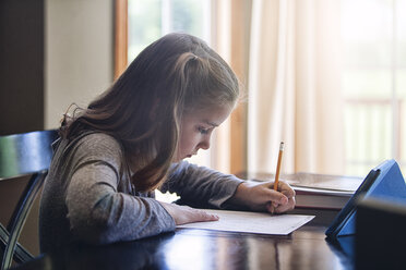 Seitenansicht eines Mädchens am Schreibtisch beim Schreiben - ISF09040