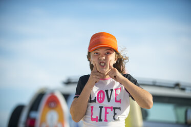 Porträt eines jungen Mädchens am Strand, das ein lustiges Gesicht zieht - ISF09060