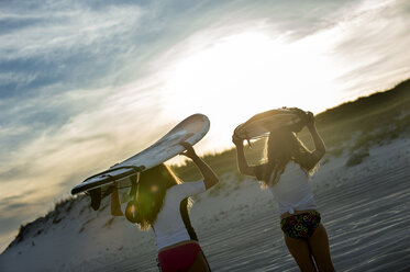 Zwei junge Mädchen im Meer, mit Surfbrettern in der Hand, Rückansicht - ISF09067