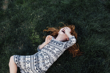 Hohe Winkel Ansicht des Mädchens auf Gras liegend bedeckt Gesicht lachend - ISF09175
