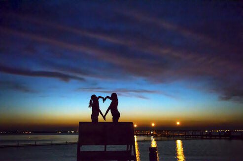 Children making heart shape with hands at sunset, Seaside Park, New Jersey, USA - ISF09179