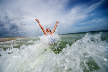 Mädchen springt vor Freude in einer Meereswelle - ISF09192