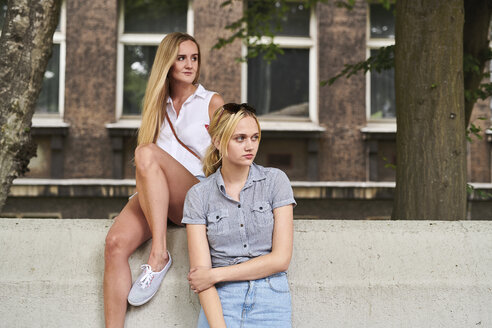 Zwei junge Frauen in der Stadt schauen zur Seite - MMIF00133