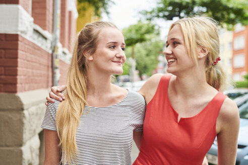 Zwei glückliche junge Frauen gemeinsam in der Stadt - MMIF00164