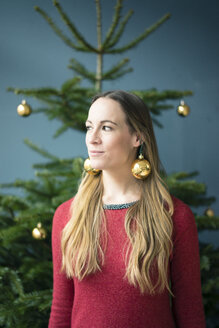 Porträt einer Frau mit goldenen Weihnachtskugel-Ohrringen - MOEF01340