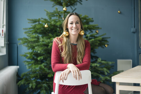 Portrait lachende Frau mit goldenen Weihnachtskugel-Ohrringen - MOEF01341