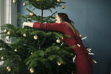 Woman hugging Christmas tree - MOEF01356