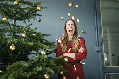 Schreiende Frau neben Weihnachtsbaum stehend - MOEF01359