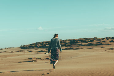 Young woman walking in desert landscape - OCAF00259