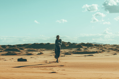 Young woman walking in desert landscape stock photo