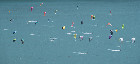 Große Gruppe von Kitesurfern auf türkisfarbenem See, Kanton Graubünden, Schweiz - CUF23123