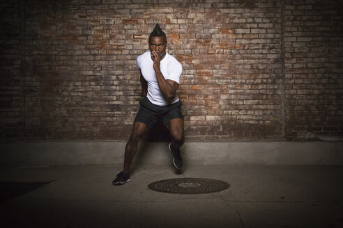 Young man with mohawk, exercising at night, in urban setting - ISF09226