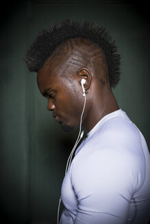 Profile of young man with mohawk wearing earphones - ISF09228