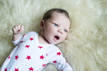 Neugeborenes Baby auf flauschiger Decke liegend und wegschauend - ISF09235