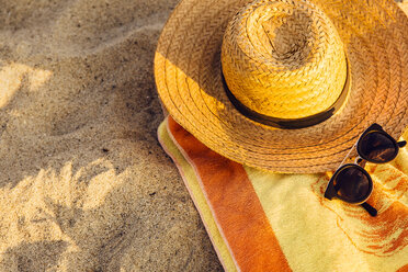 Sonnenbrille, Strohhut und Strandtuch im Sand - ISF09253