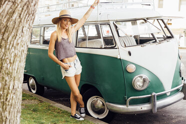 Woman by vintage camper van looking at camera - ISF09264