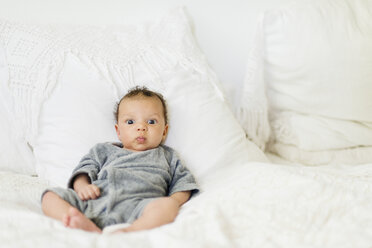 Baby sitzt auf dem Bett - ISF09267