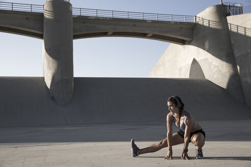 Female athlete with headphones, stretching, Van Nuys, California, USA - ISF09282