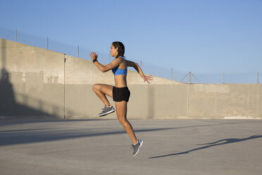 Weibliche Athletin bei einer Übung mit hohen Knien, Van Nuys, Kalifornien, USA - ISF09287