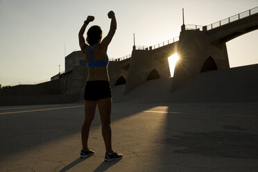 Weibliche Athletin beim Dehnen bei Sonnenuntergang, Van Nuys, Kalifornien, USA - ISF09295