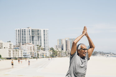 Älterer Mann, der am Strand in Yoga-Position trainiert, Long Beach, Kalifornien, USA - ISF09327