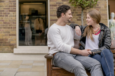 Romantic young couple sitting on bench, Kings Road, London, UK - CUF23144