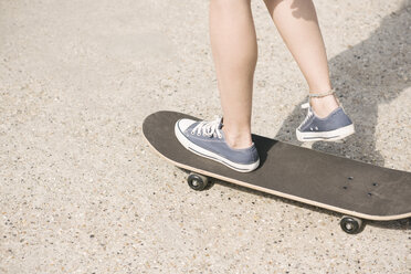 Legs of young female skateboarder skateboarding - CUF23157