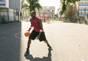 Young man practising on basketball court - CUF23178