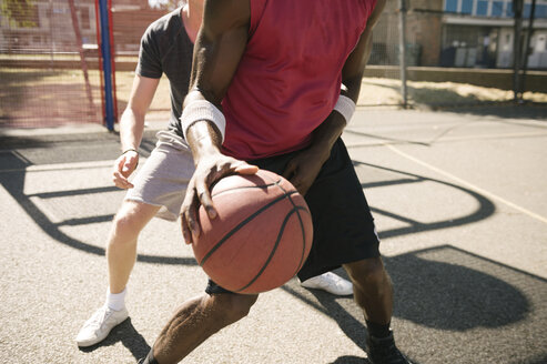 Mittelteil von zwei männlichen Basketballspielern beim Training auf dem Basketballplatz - CUF23181