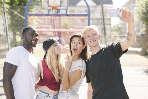 Vier erwachsene Freunde posieren für ein Smartphone-Selfie auf dem Basketballplatz - CUF23187