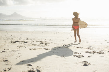 Young female surfer on sunlit beach, Cape Town, Western Cape, South Africa - CUF23203