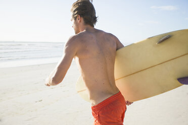 Junger männlicher Surfer läuft am Strand, Kapstadt, Westkap, Südafrika - CUF23206