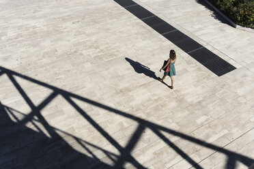 Blick von oben auf eine Frau im Sommerkleid, die über einen Platz läuft, Rom, Latium, Italien - CUF23214