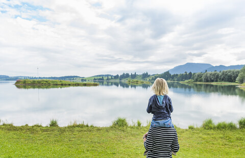 Rückansicht einer Großmutter, die ihren Enkel auf den Schultern trägt, Füssen, Bayern, Deutschland, lizenzfreies Stockfoto