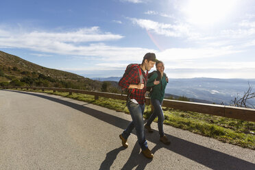 Hikers on sidewalk by hillside, Montseny, Barcelona, Catalonia, Spain - CUF23288