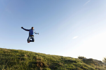 Hiker jumping on hilltop, Montseny, Barcelona, Catalonia, Spain - CUF23299