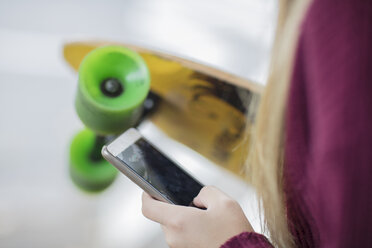 Nahaufnahme eines Teenagers mit Skateboard und Handy - ZEF15597